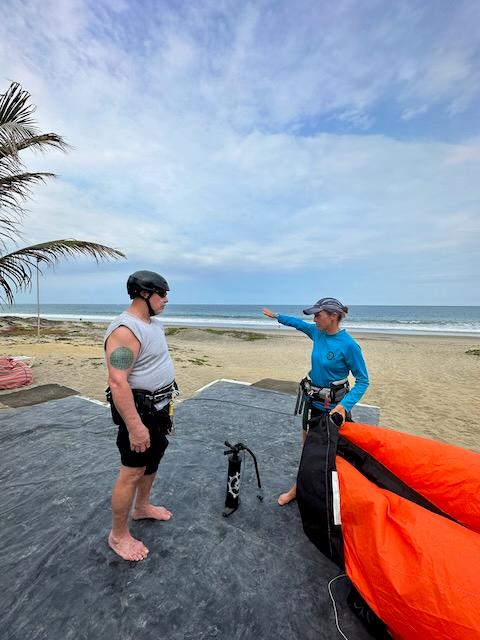 A kitesurf instructor teaching to set up equipment